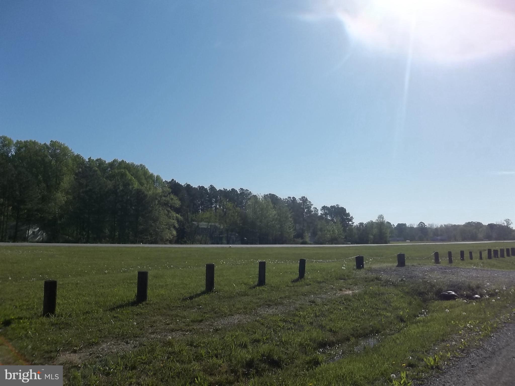 12820 Rousby Hall Road Lusby, MD 20657 - Photo 32 of 39 a view of a green field with trees in the background