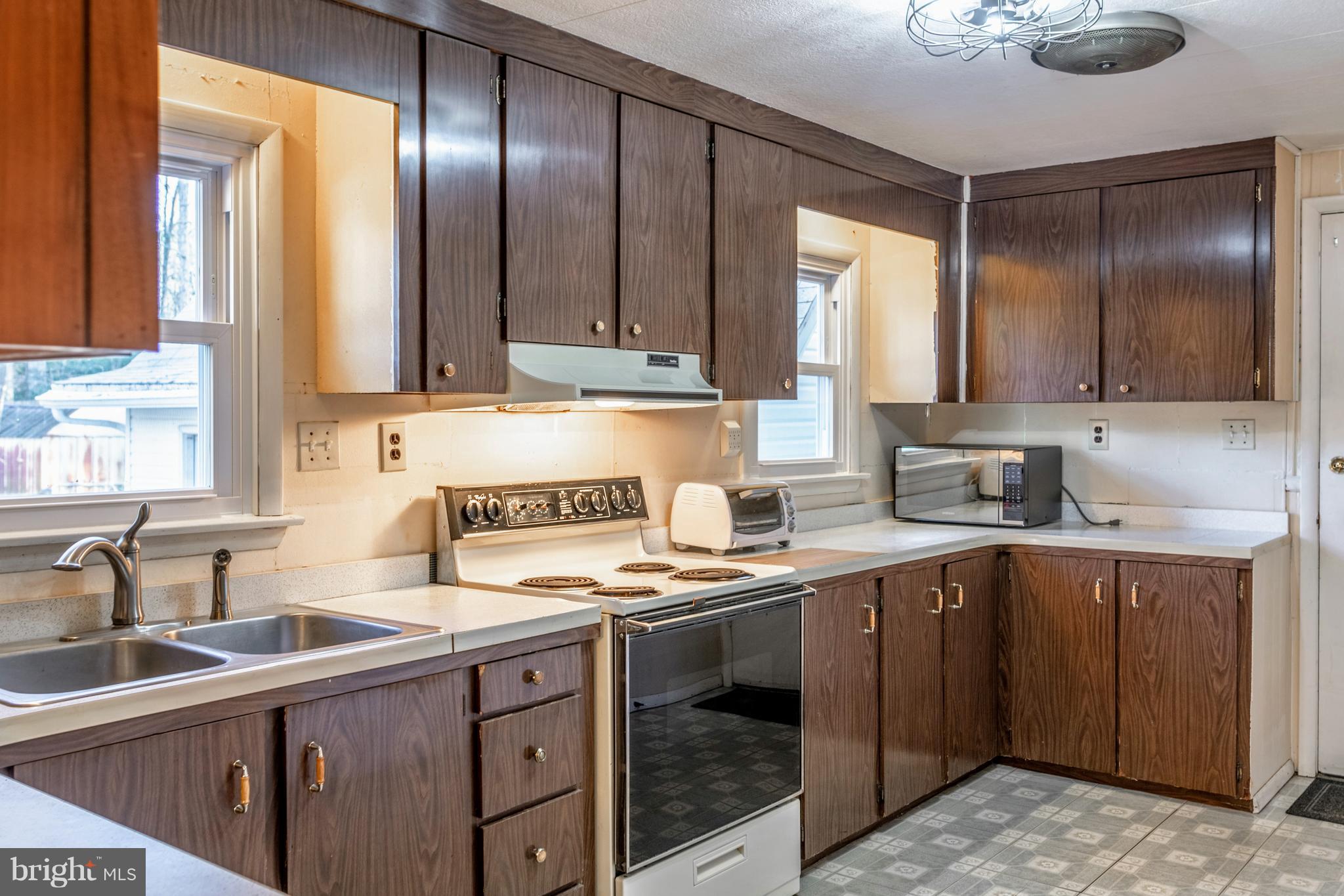 12820 Rousby Hall Road Lusby, MD 20657 - Photo 7 of 39 a kitchen with a sink stove and cabinets