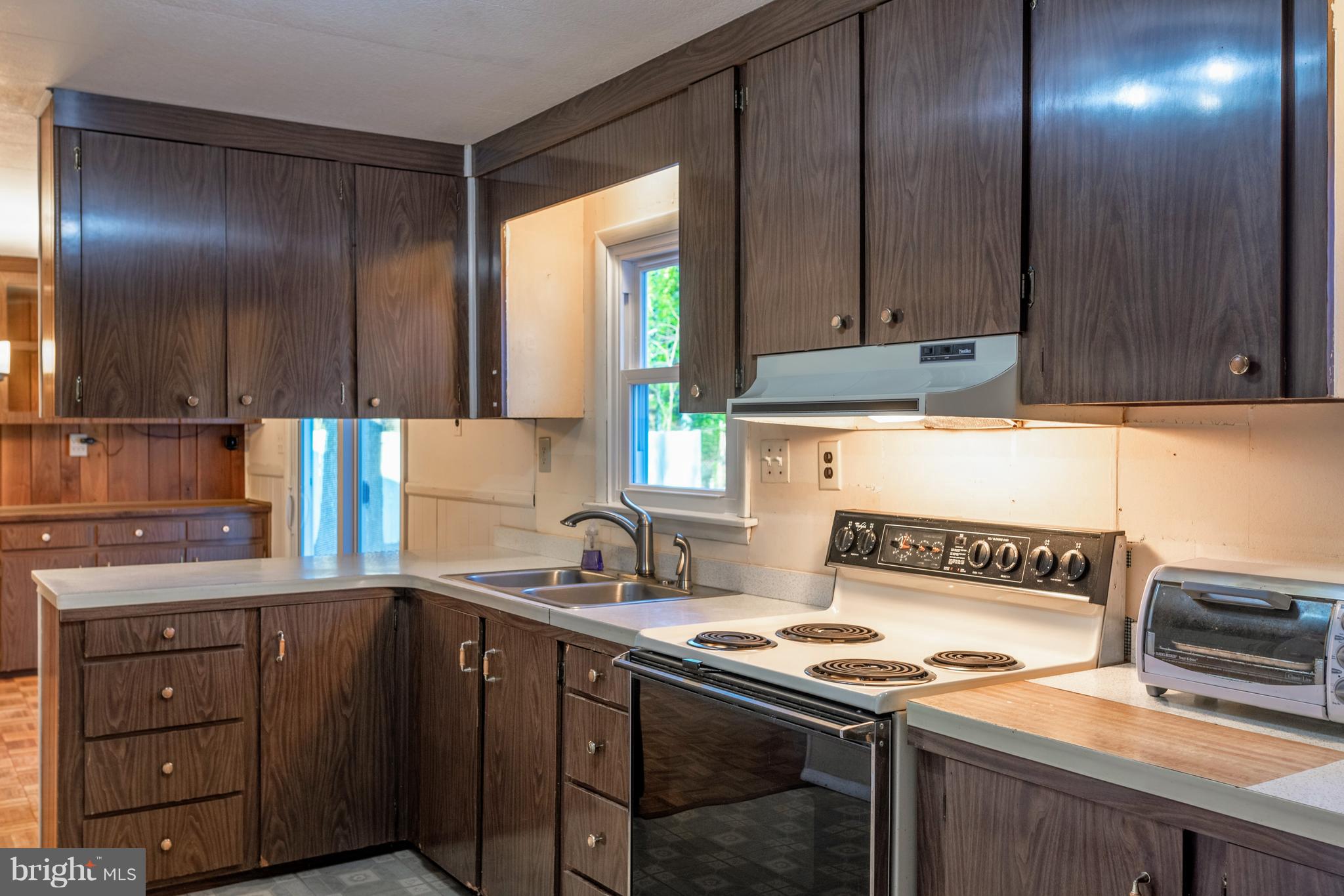12820 Rousby Hall Road Lusby, MD 20657 - Photo 8 of 39 a kitchen with a refrigerator and a sink