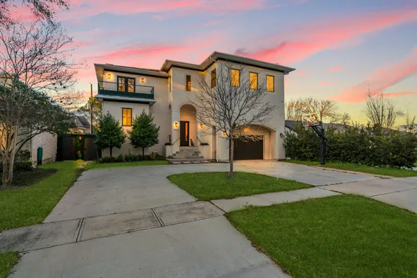 a front view of a house with a yard and trees