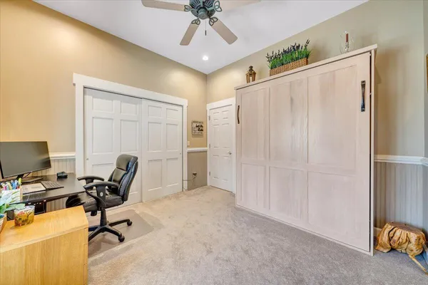 a view of house with garden space and trees in the background