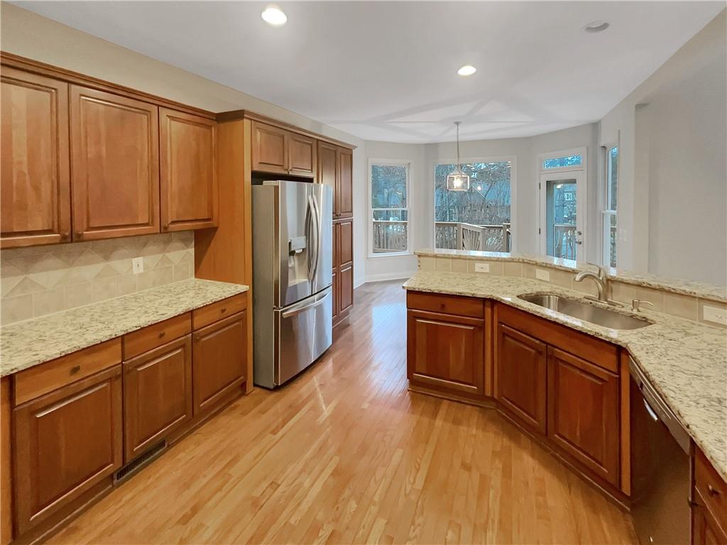 37 Ashdowne Way Acworth, GA 30101 - Photo 8 of 31 a kitchen with stainless steel appliances granite countertop a refrigerator a sink dishwasher and wooden cabinets with wooden floor