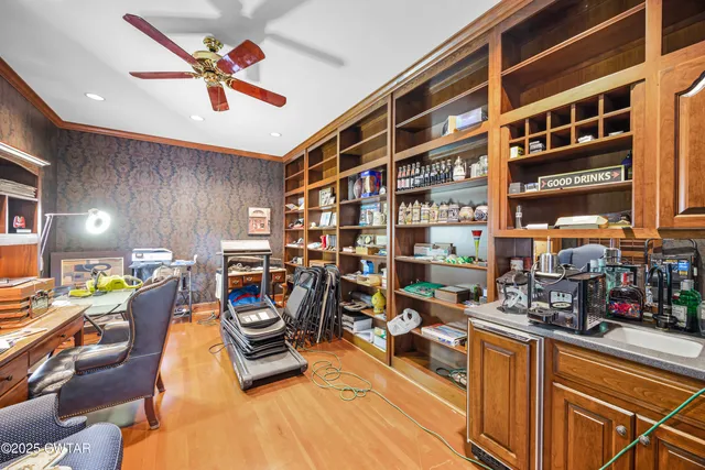 a spacious bedroom with a bed a dresser and wooden floor