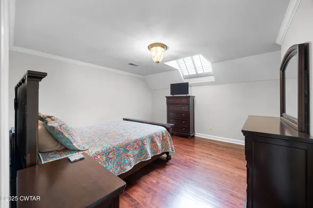 a room with a bed and a table with wooden floor