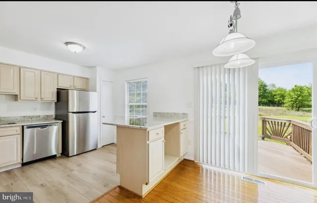 a kitchen with stainless steel appliances granite countertop a refrigerator and a stove