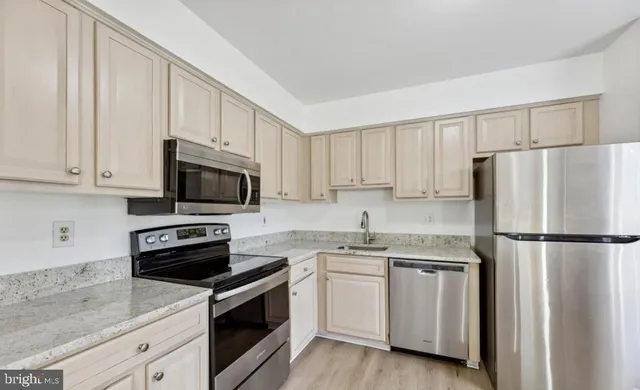 a kitchen with white cabinets and white appliances