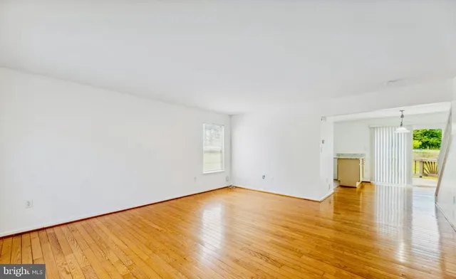 a view of empty room with wooden floor and wooden floor