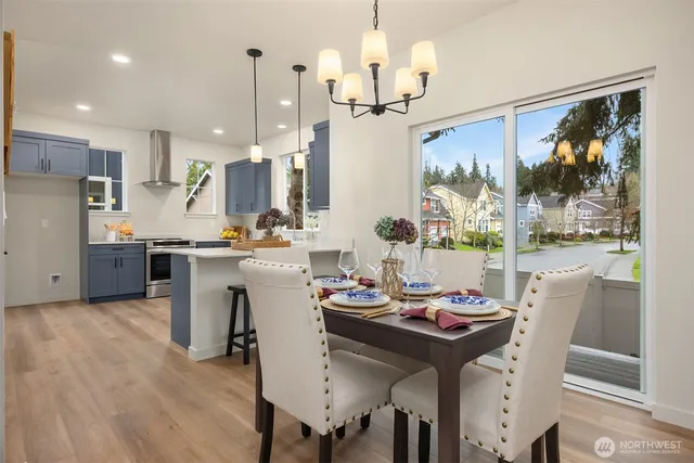 a view of a dining room and livingroom with furniture wooden floor a chandelier