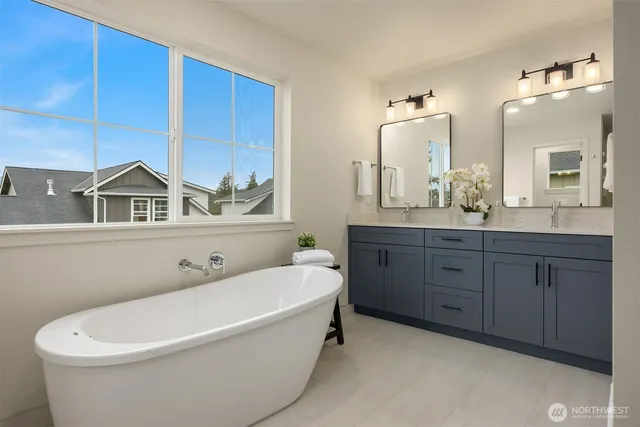 a spacious bathroom with double vanity sinks a large mirror and a bathtub
