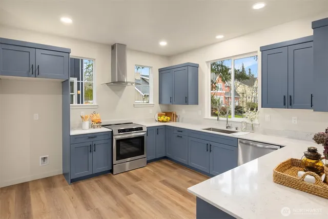 a large kitchen with stainless steel appliances granite countertop a stove a sink dishwasher and a refrigerator