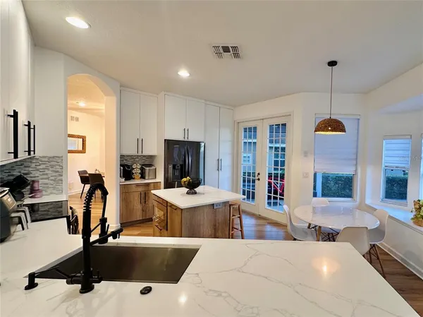 a living room with furniture a flat screen tv and kitchen view