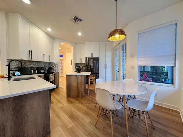 a view of a dining room with furniture a kitchen and chandelier