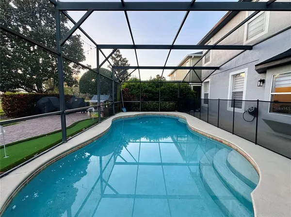 a view of a swimming pool with a patio and a yard