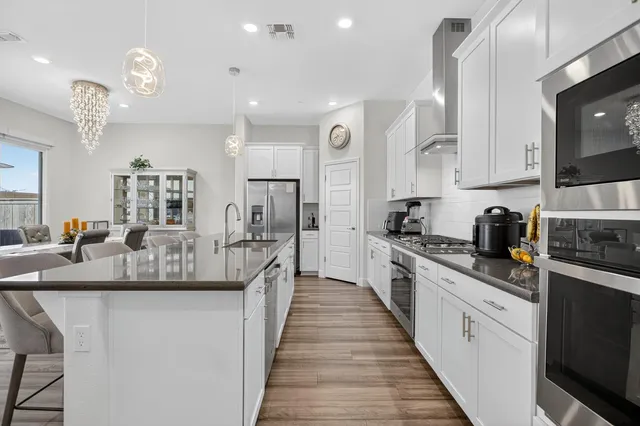 a kitchen with stainless steel appliances granite countertop a white cabinets and wooden floor