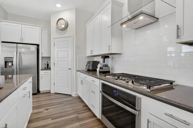 a view of a kitchen with kitchen island stainless steel appliances a sink and living room view