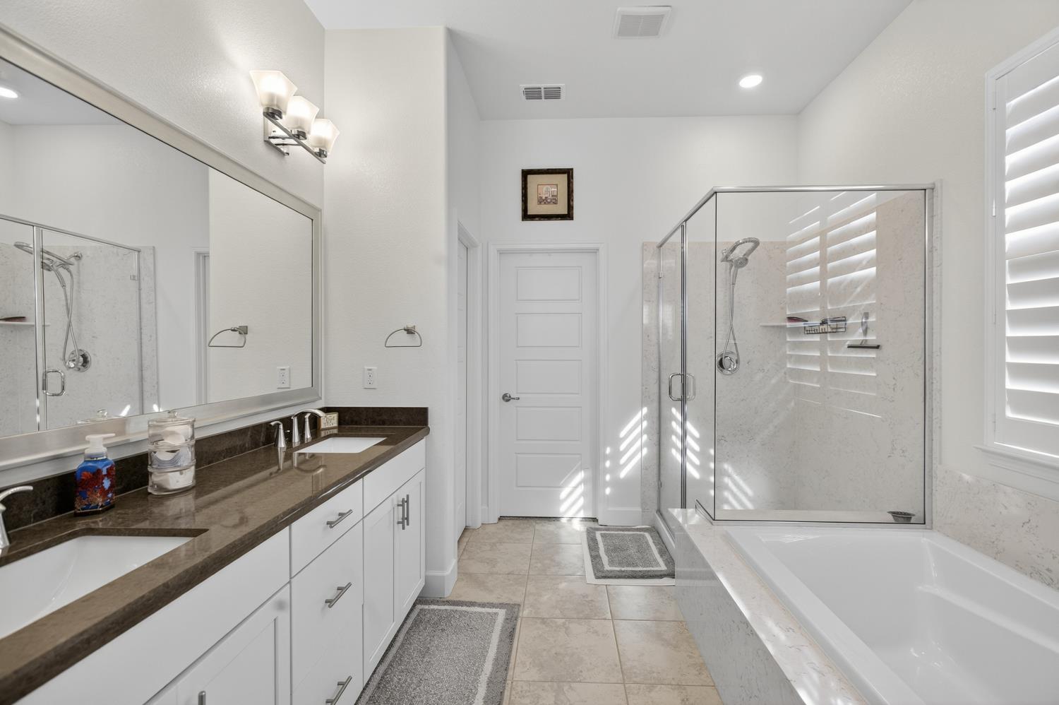 5603 Drifton Way Sacramento, CA 95835 - Photo 35 of 49 a spacious bathroom with a granite countertop tub sink shower and mirror
