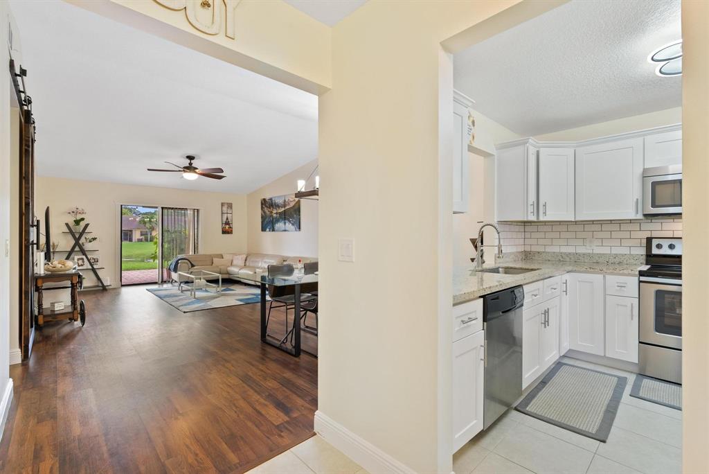 6734 Bridlewood Court, Unit 6734 Boca Raton, FL 33433 - Photo 11 of 42 a kitchen with sink cabinets and wooden floor