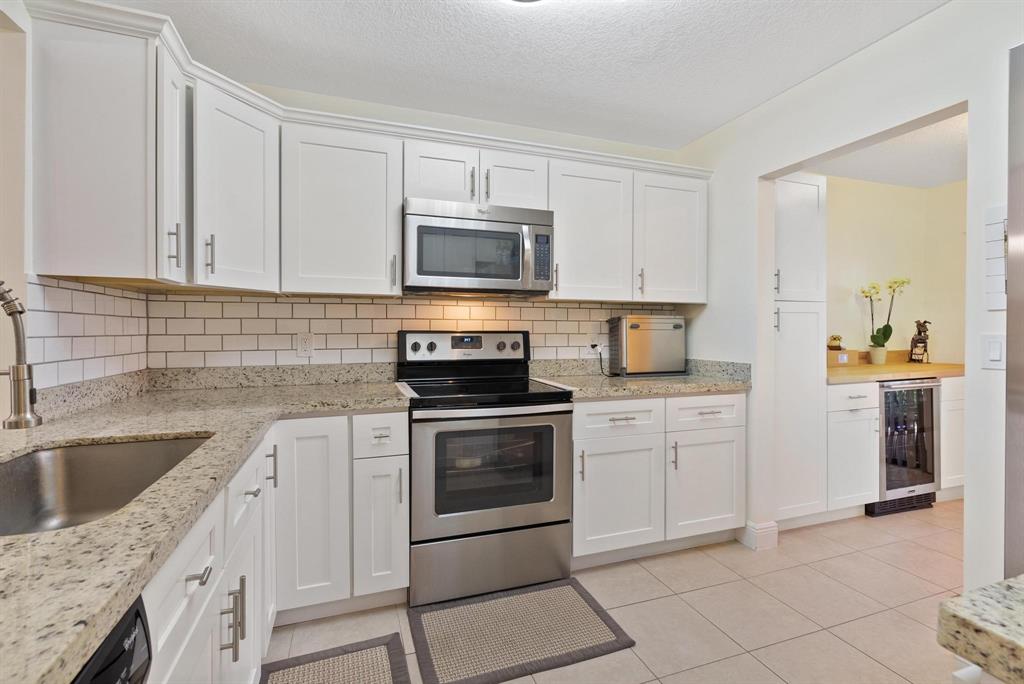 6734 Bridlewood Court, Unit 6734 Boca Raton, FL 33433 - Photo 13 of 42 a kitchen with cabinets stainless steel appliances and a sink