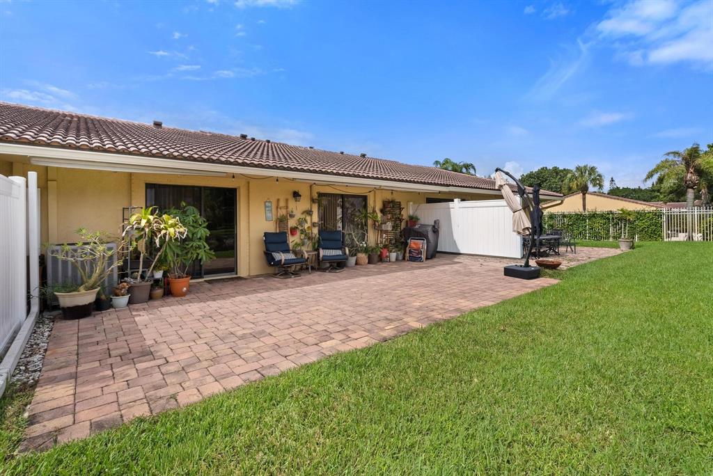 6734 Bridlewood Court, Unit 6734 Boca Raton, FL 33433 - Photo 27 of 42 a view of a patio with table and chairs a barbeque and potted plants