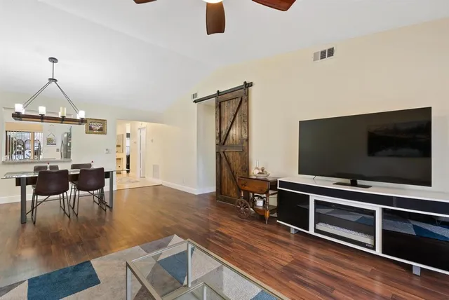 a living room with furniture a dining table and a chandelier