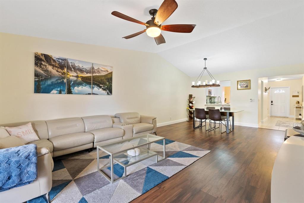 6734 Bridlewood Court, Unit 6734 Boca Raton, FL 33433 - Photo 9 of 42 a living room with furniture a dining table and a chandelier