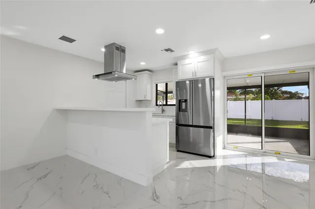 a kitchen with refrigerator a counter top space and stainless steel appliances