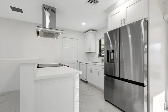 a kitchen with stainless steel appliances a refrigerator and a stove top oven