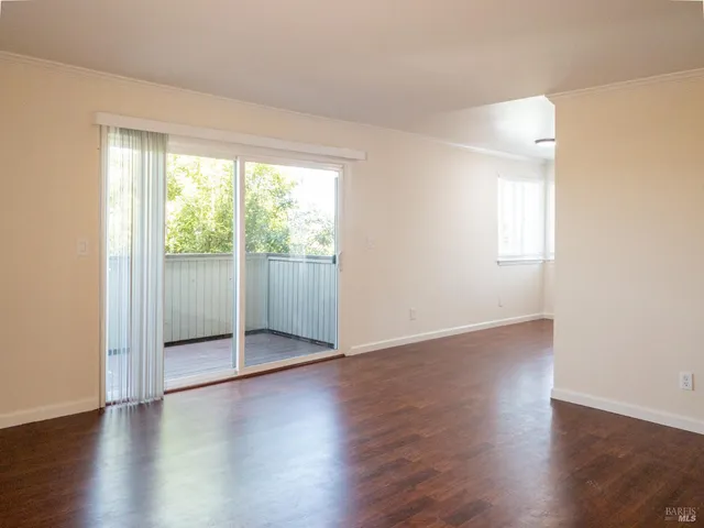 an empty room with wooden floor and sliding door