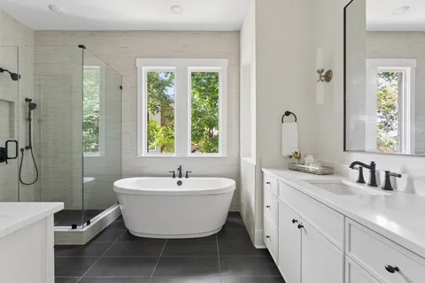 a bathroom with a bathtub sink vanity mirror and toilet