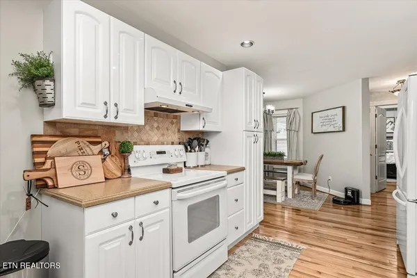 a kitchen with white cabinets and white appliances