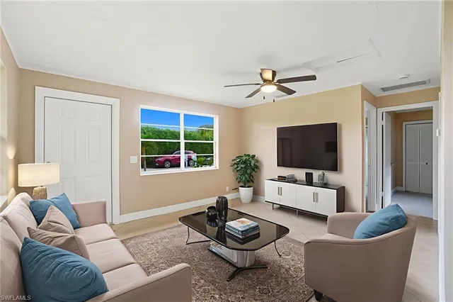 a living room with furniture a window and a flat screen tv