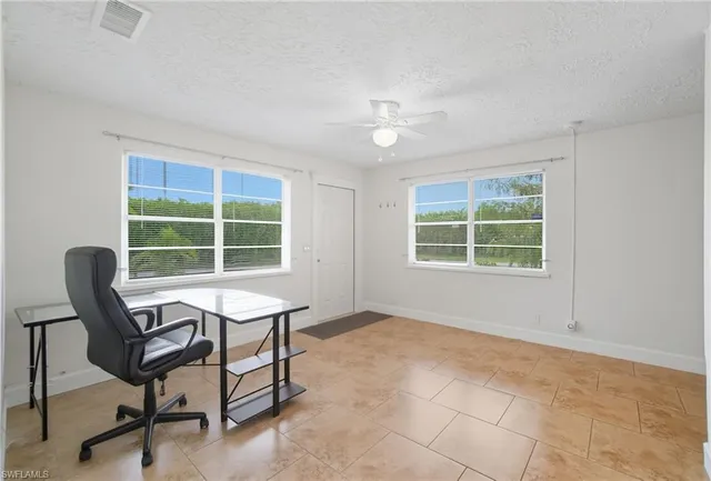 a view of a workspace with furniture and a window