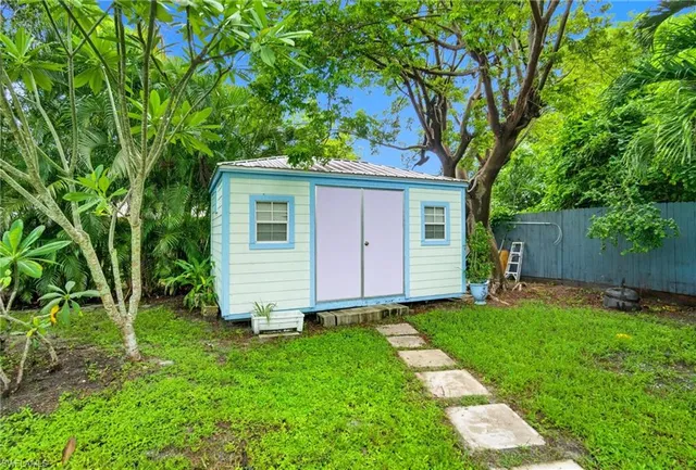a view of backyard with a barn and large trees