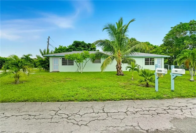 a front view of a house with a garden and yard