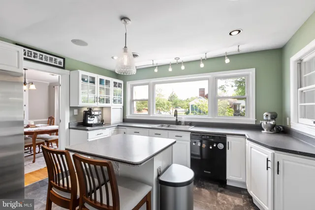 a kitchen with a table chairs sink and cabinets