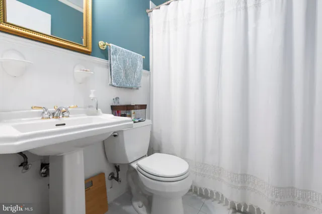 a bathroom with a sink a toilet and a mirror