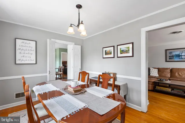 a view of a dining room with furniture a chandelier and wooden floor