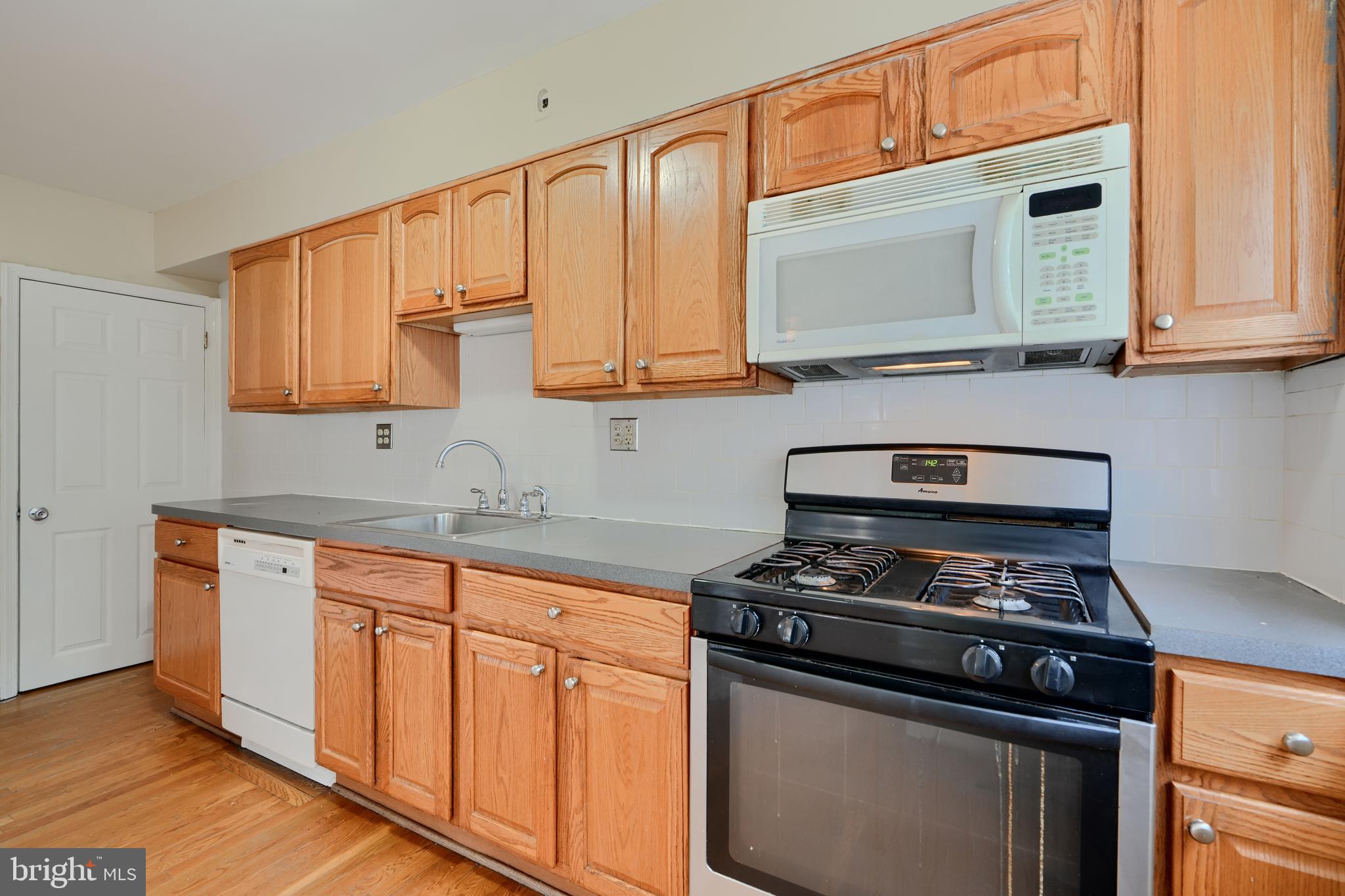 910 Radcliffe Road Towson, MD 21204 - Photo 11 of 32 a kitchen with granite countertop a stove top oven cabinetry a sink and a granite counter top