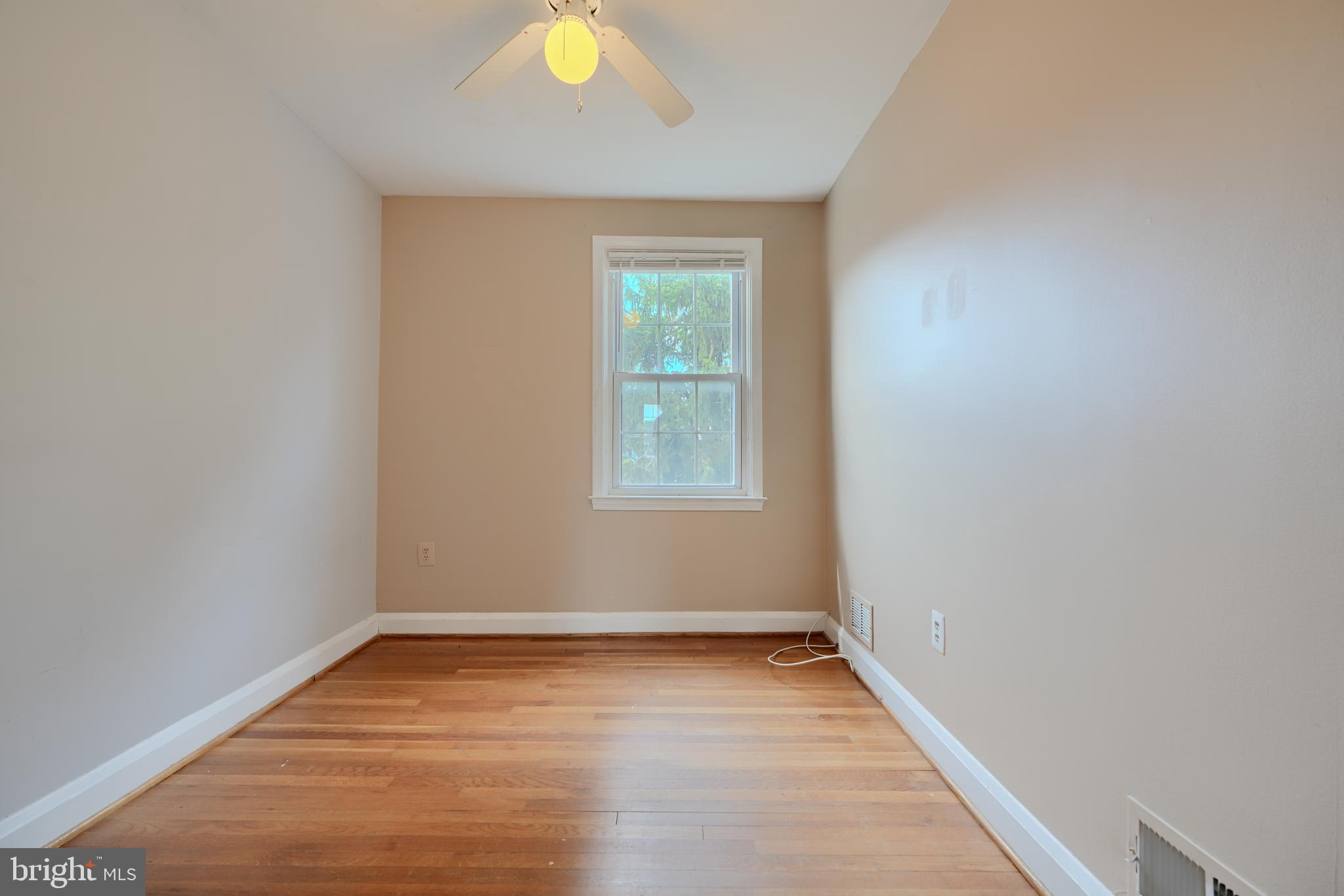 910 Radcliffe Road Towson, MD 21204 - Photo 16 of 32 a view of an empty room with wooden floor and a window