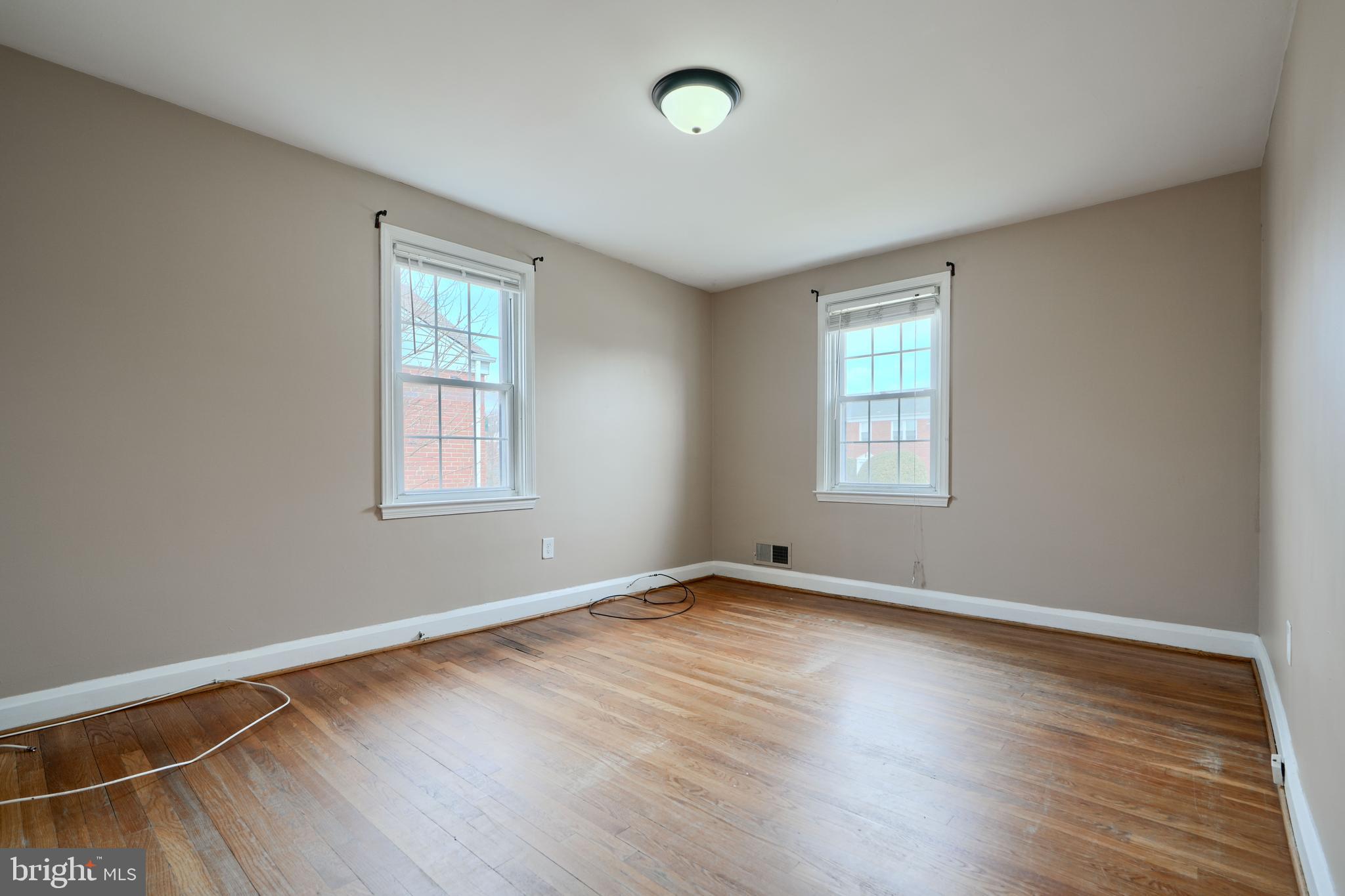 910 Radcliffe Road Towson, MD 21204 - Photo 20 of 32 an empty room with wooden floor and windows
