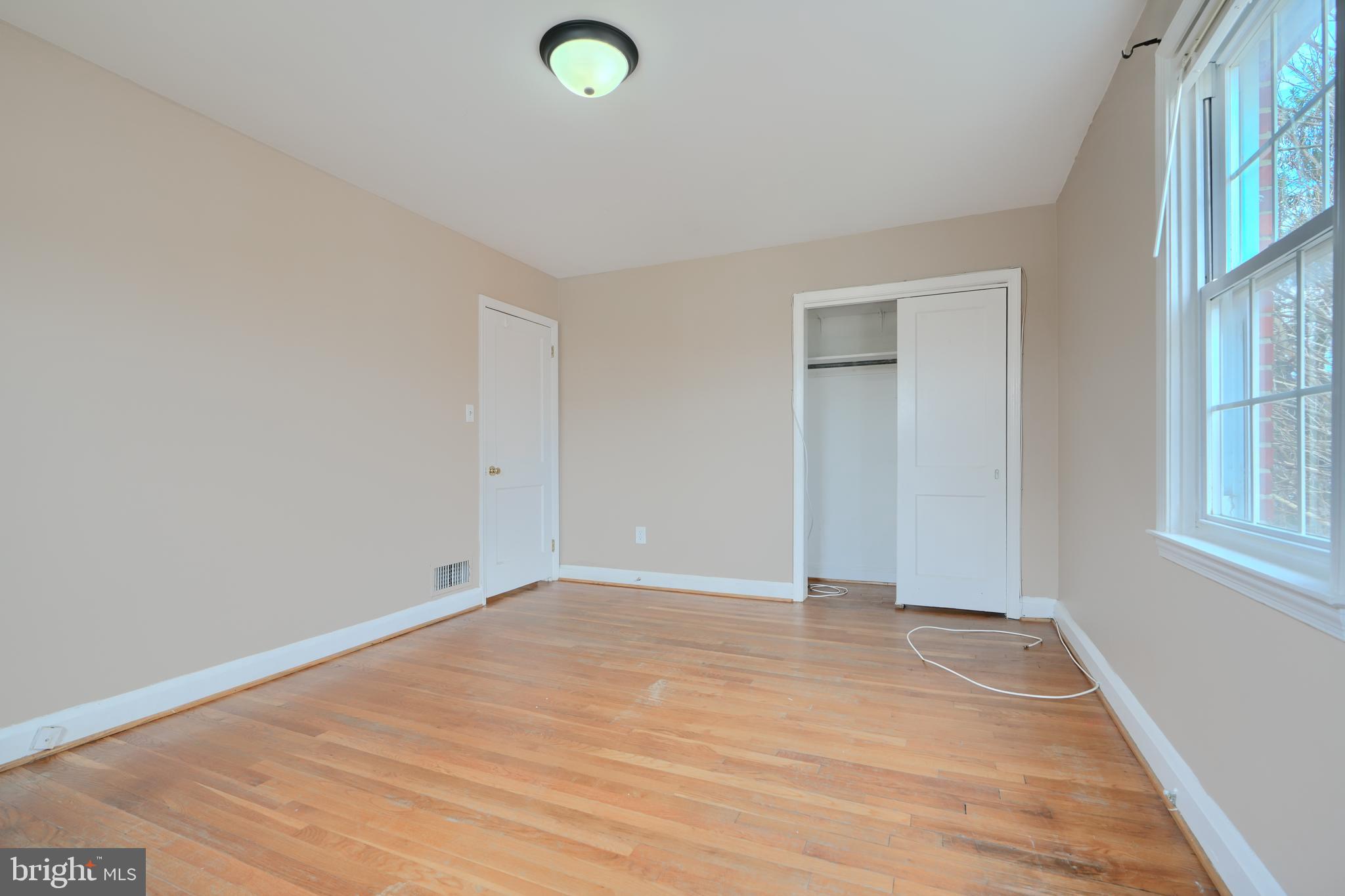 910 Radcliffe Road Towson, MD 21204 - Photo 21 of 32 an empty room with wooden floor and windows