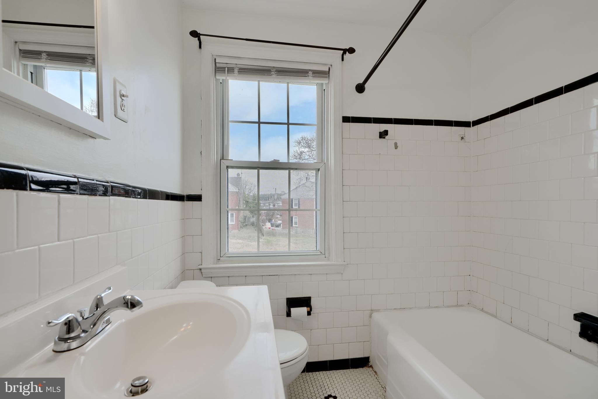 910 Radcliffe Road Towson, MD 21204 - Photo 22 of 32 a bathroom with a sink a window and a shower