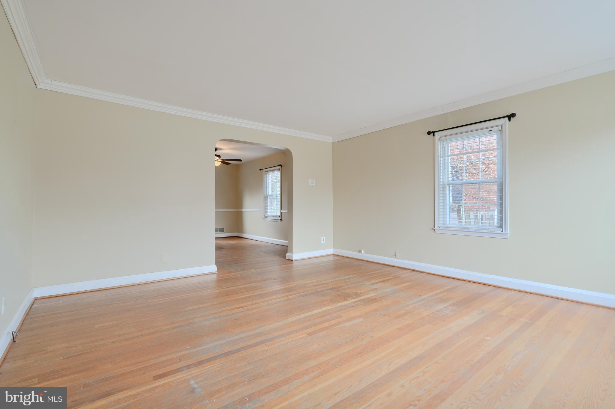 910 Radcliffe Road Towson, MD 21204 - Photo 3 of 32 a view of an empty room with wooden floor and a window