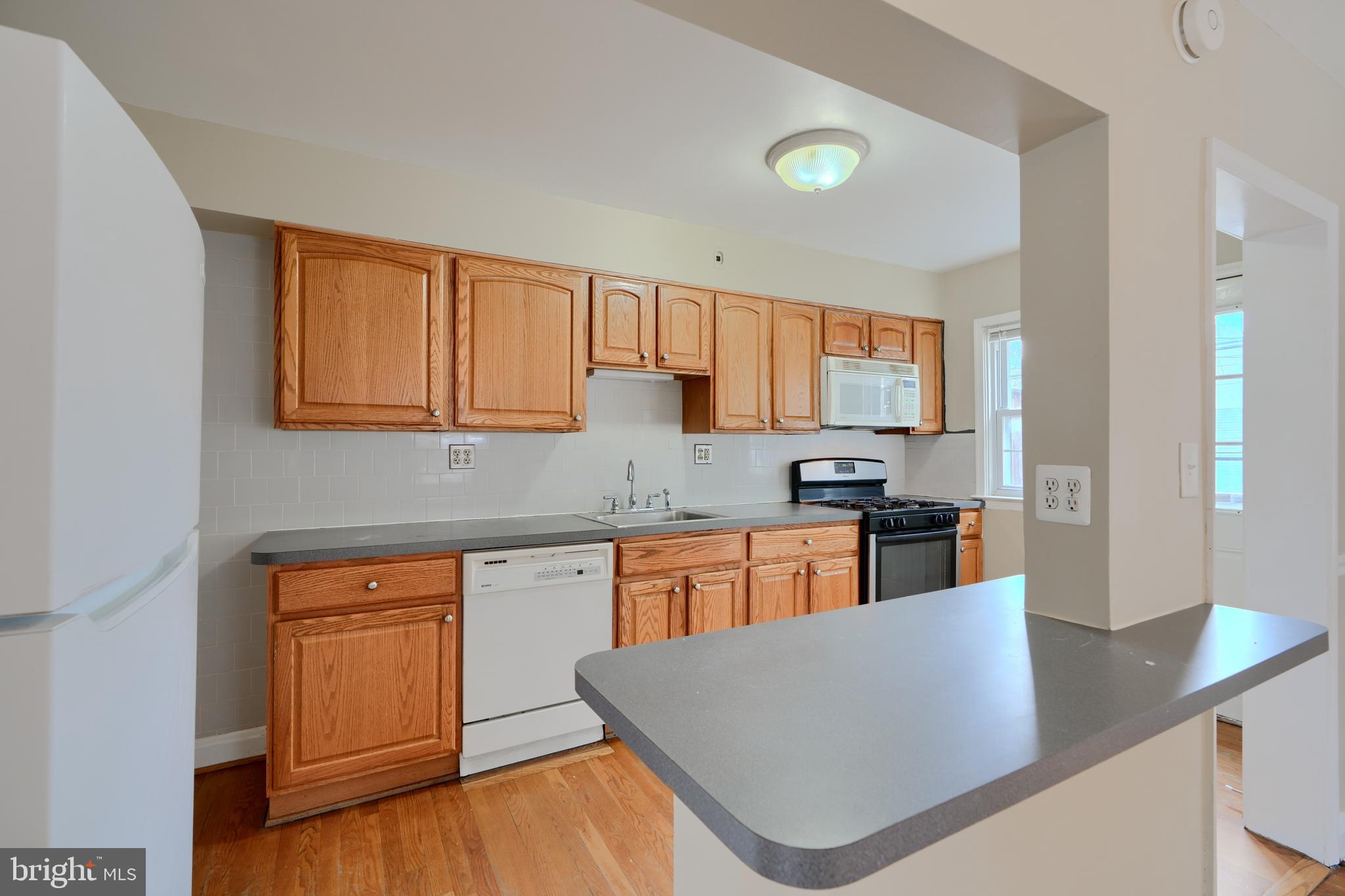910 Radcliffe Road Towson, MD 21204 - Photo 8 of 32 a kitchen with stainless steel appliances granite countertop a sink dishwasher stove refrigerator and cabinets