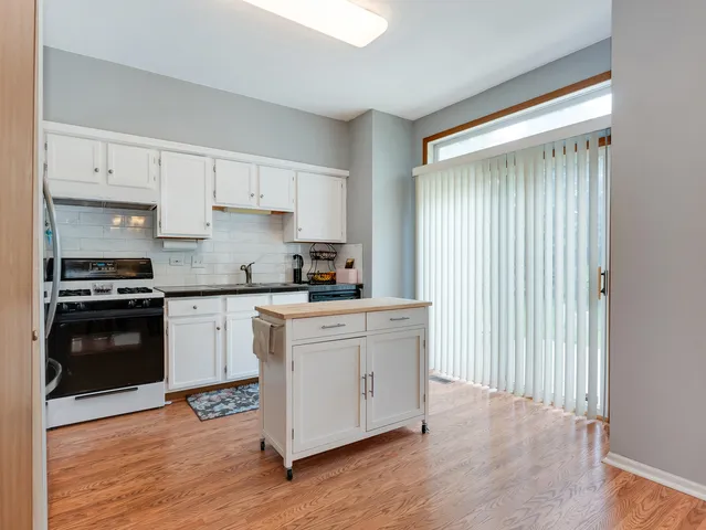 a kitchen with granite countertop white cabinets and black appliances