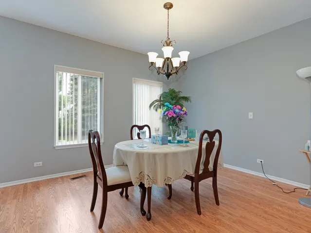 a view of a dining room with furniture a chandelier and wooden floor