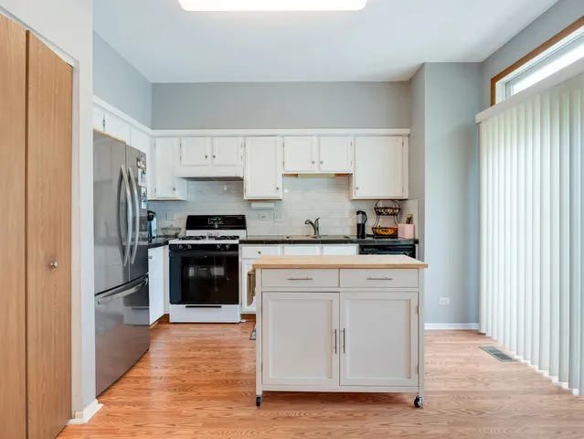 a kitchen with stainless steel appliances granite countertop a refrigerator and a stove top oven