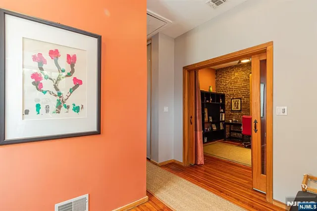 a view of a hallway with wooden floor and a workspace