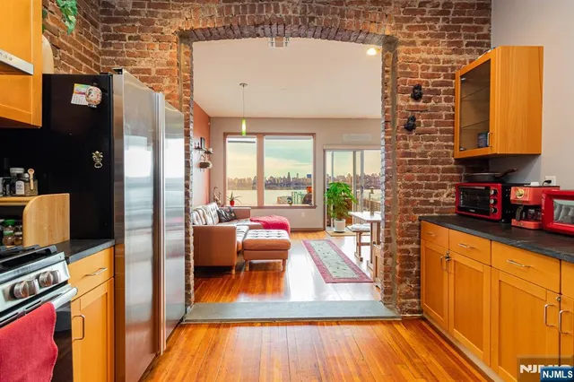 a living room with furniture a wooden floor and next to a window