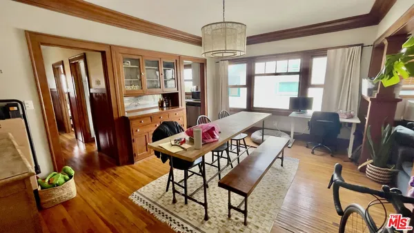 a dining room with furniture a chandelier and wooden floor